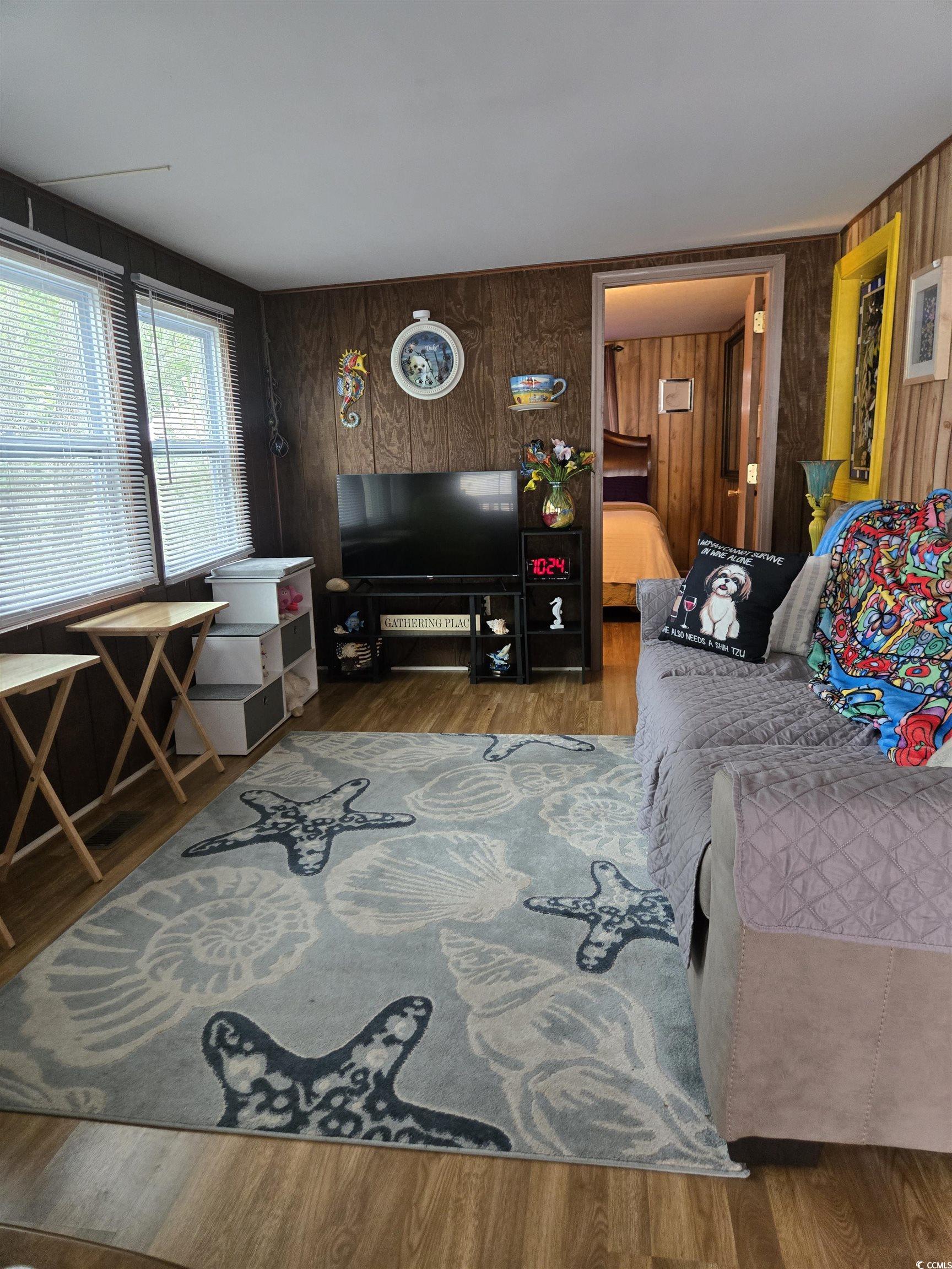 348 Bridge Street Murrells Inlet, SC 29576 - Photo 13 of 28 Living area featuring wood finished floors and wood walls