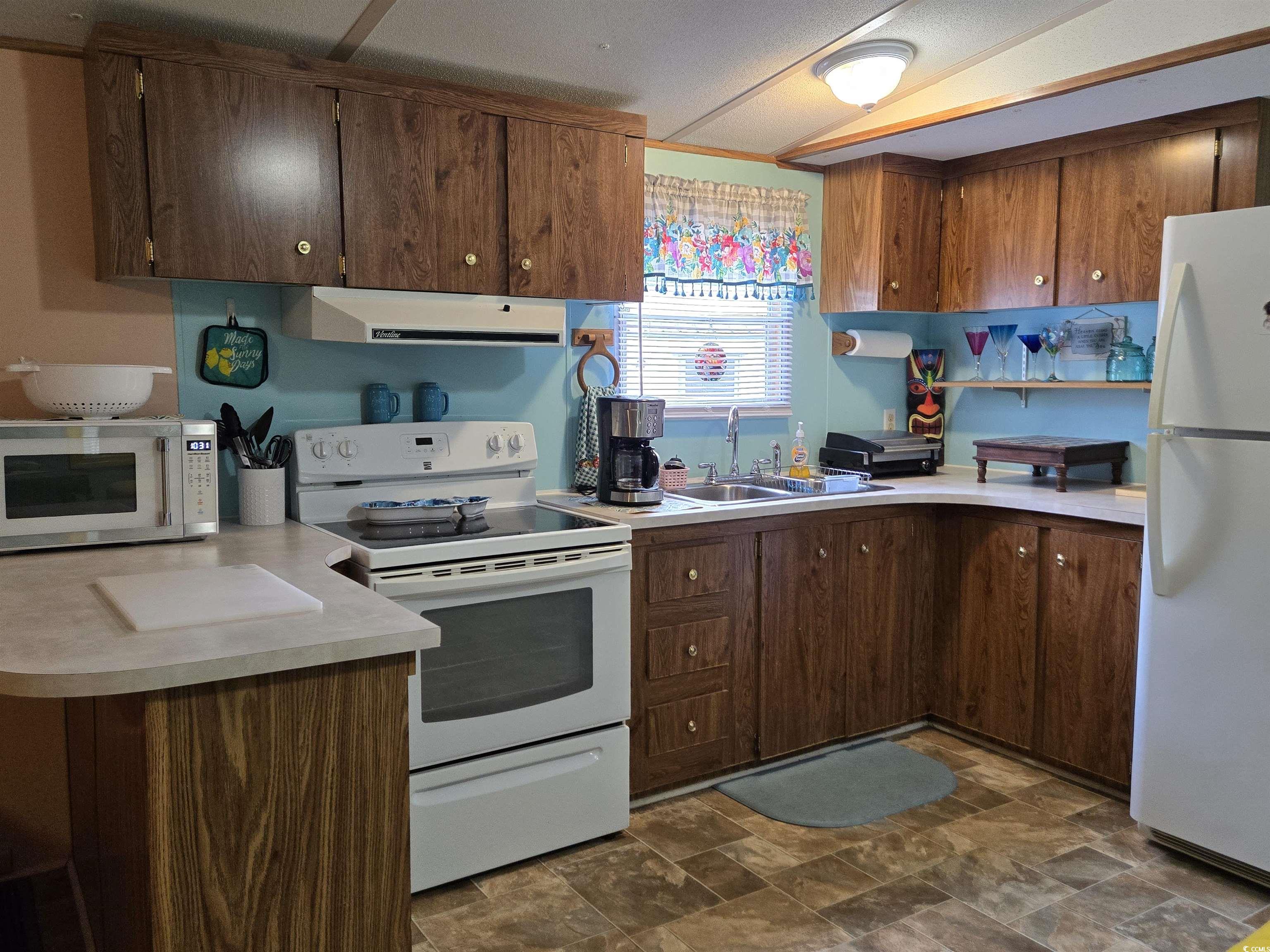 348 Bridge Street Murrells Inlet, SC 29576 - Photo 19 of 28 Kitchen featuring white appliances, ventilation hood, a sink, and light countertops