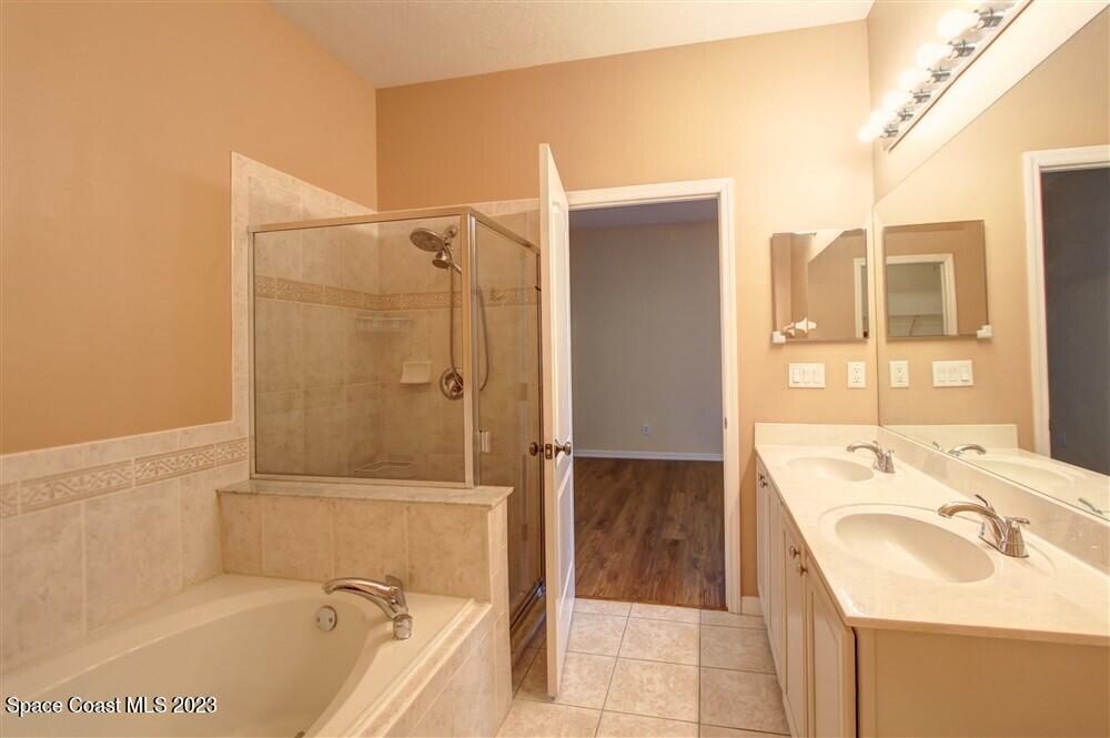 264 Intrepid Way Indialantic, FL 32903 - Photo 16 of 36 a bathroom with a granite countertop sink a mirror and bathtub