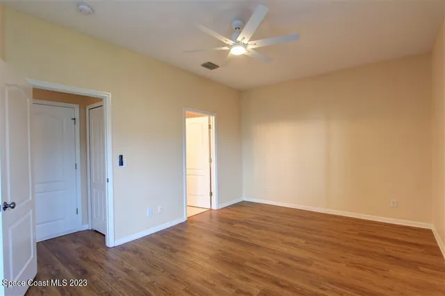 a view of an empty room with wooden floor