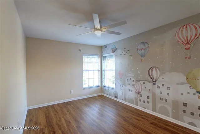 a view of empty room with window and wooden floor