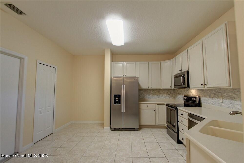264 Intrepid Way Indialantic, FL 32903 - Photo 33 of 36 a kitchen with stainless steel appliances granite countertop a sink and cabinets
