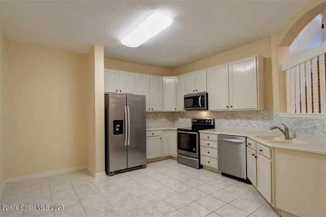 a kitchen with stainless steel appliances granite countertop a refrigerator sink and stove