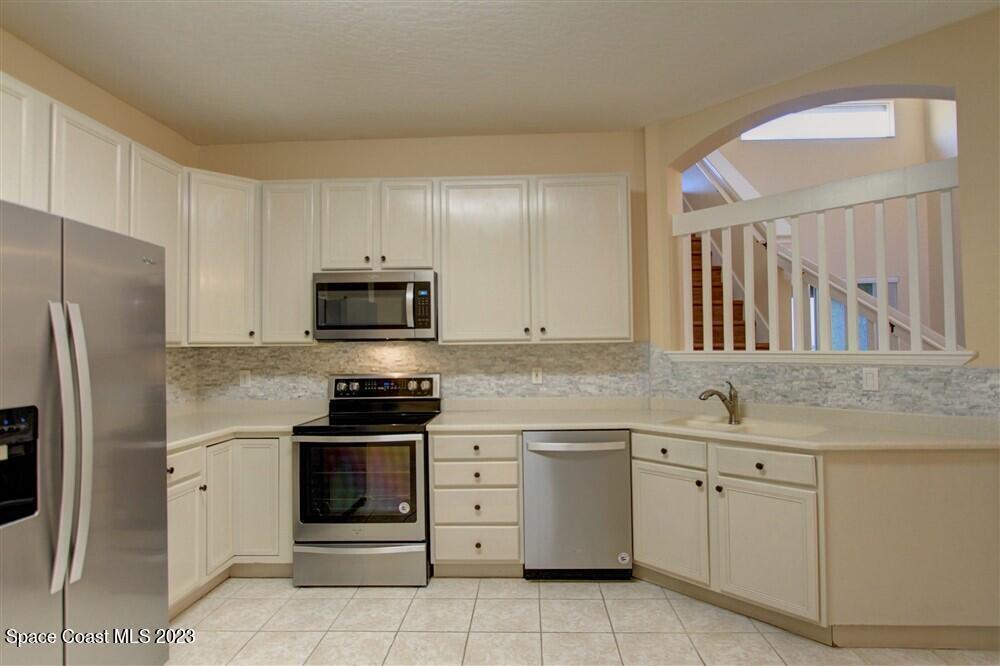 264 Intrepid Way Indialantic, FL 32903 - Photo 6 of 36 a kitchen with white cabinets and stainless steel appliances