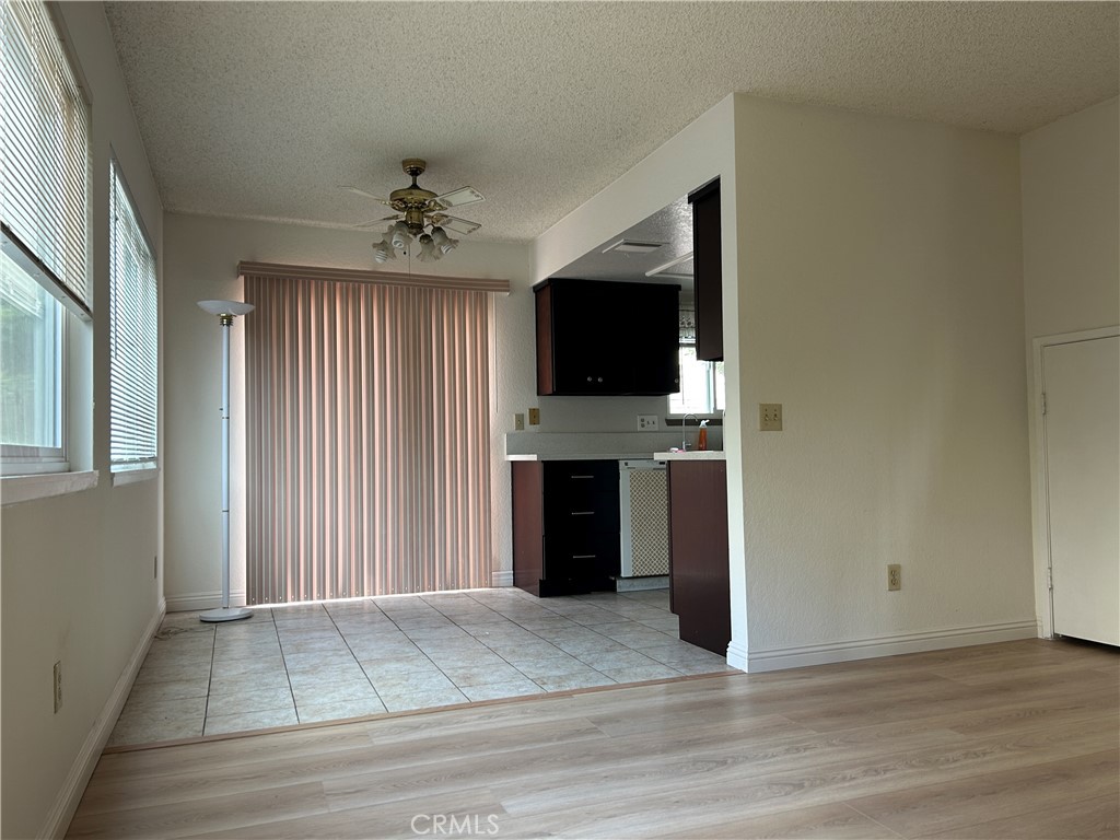 7221 Daybreak Place Rancho Cucamonga, CA 91701 - Photo 11 of 24 an empty room with windows fireplace and a chandelier fan