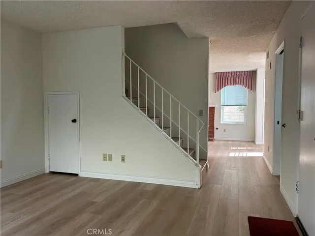 a view of a hallway with wooden floor and staircase