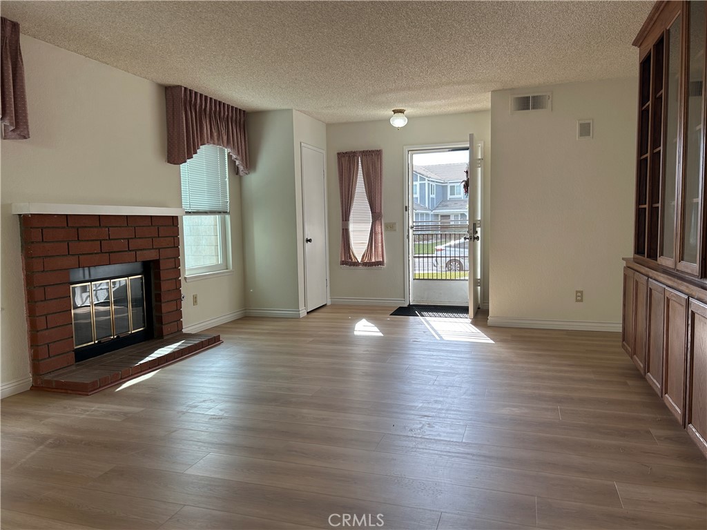 7221 Daybreak Place Rancho Cucamonga, CA 91701 - Photo 7 of 24 an empty room with wooden floor fireplace and windows