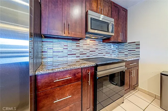 a kitchen with granite countertop a stove microwave and oven