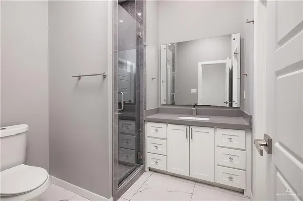 a bathroom with a granite countertop sink a toilet and a mirror