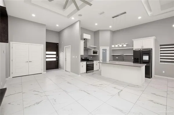 a large white kitchen with cabinets and stainless steel appliances