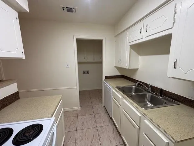 a kitchen with white cabinets and white appliances