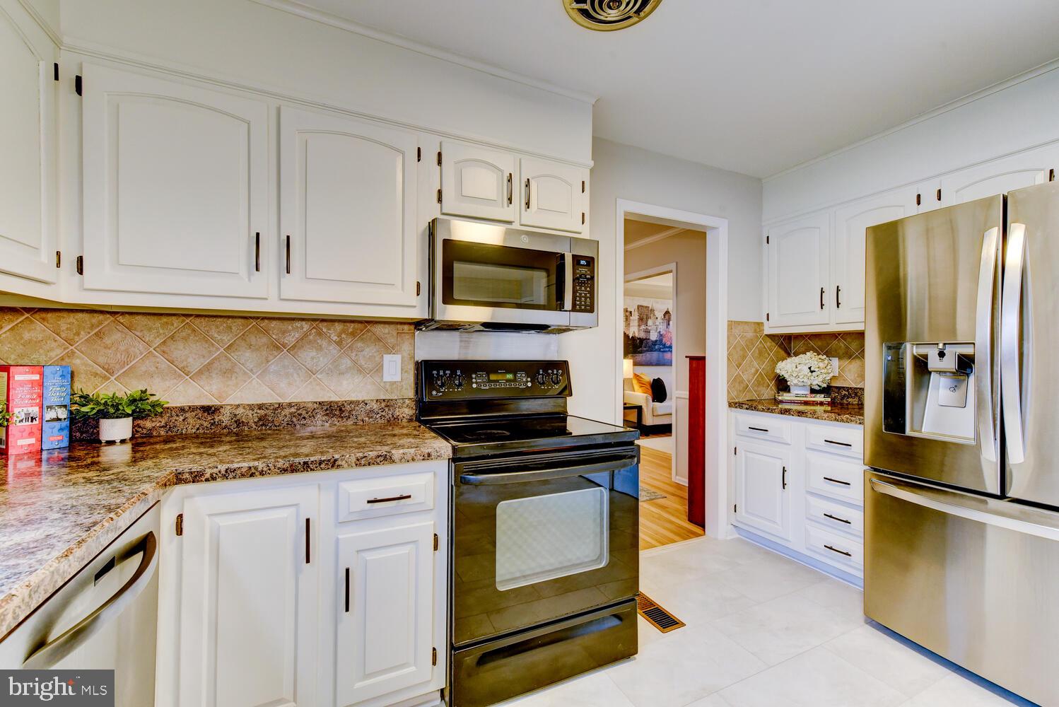 6 Coventry Circle Princeton Junction, NJ 08550 - Photo 19 of 70 a kitchen with granite countertop a stove top oven a refrigerator a sink and dishwasher with white cabinets