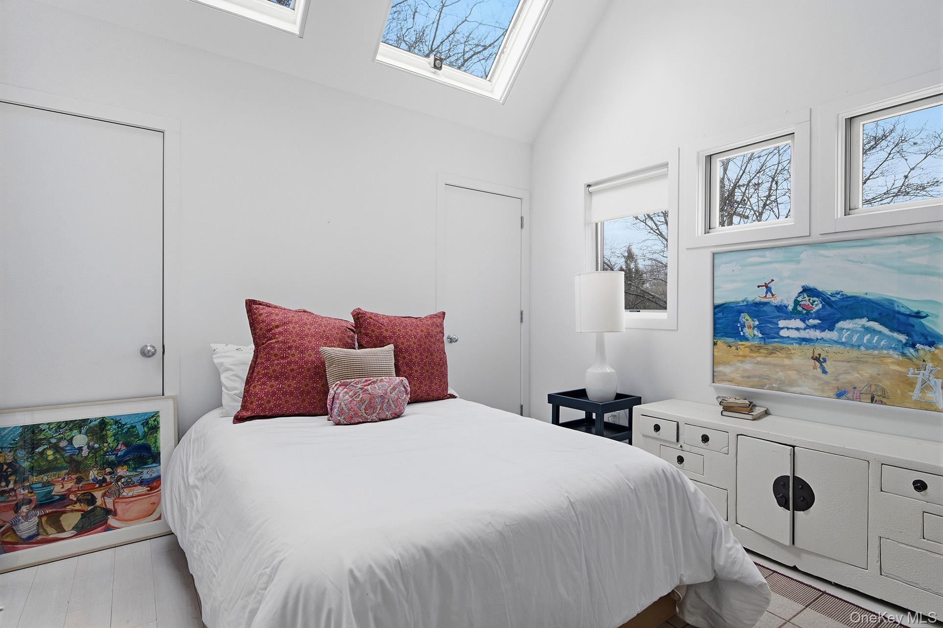 60 Skimhampton Road East Hampton, NY 11937 - Photo 20 of 37 a bedroom with a bed and painting on the wall