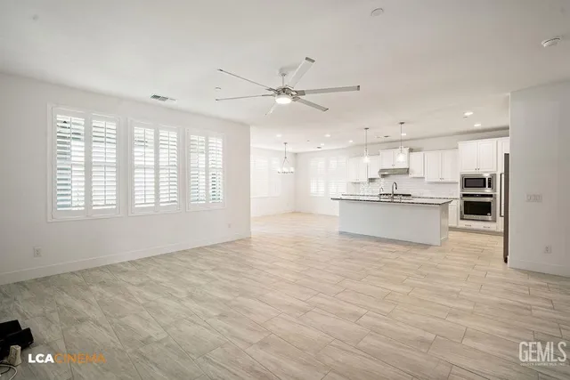 a large kitchen with granite countertop a large counter top stainless steel appliances and cabinets