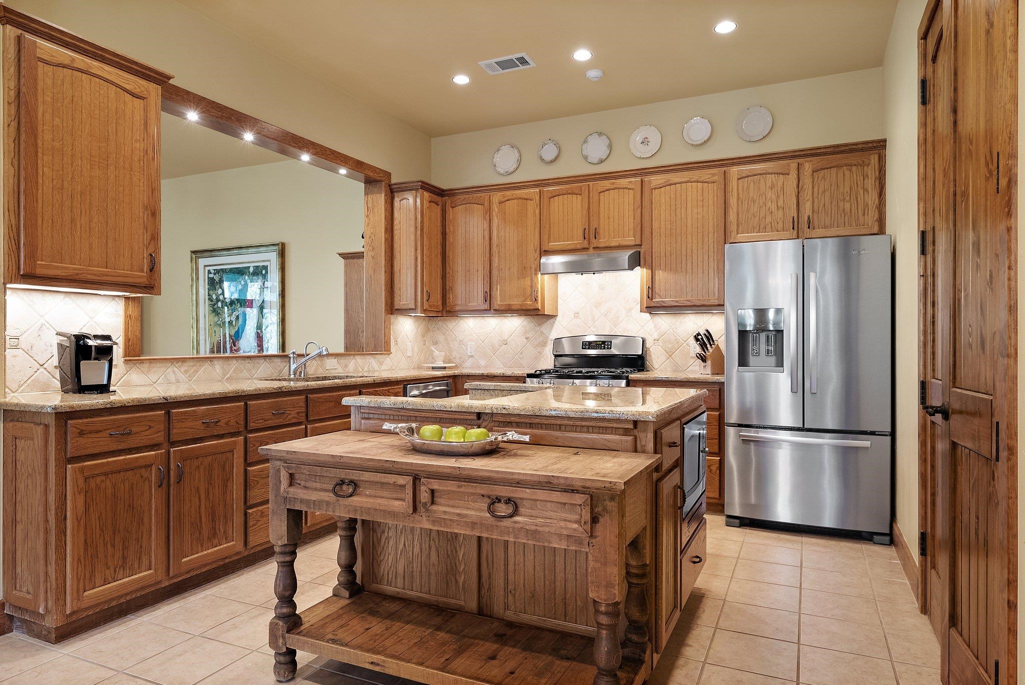 304 Hi Ridge Road Horseshoe Bay, TX 78657 - Photo 20 of 30 a kitchen with a refrigerator a sink and cabinets