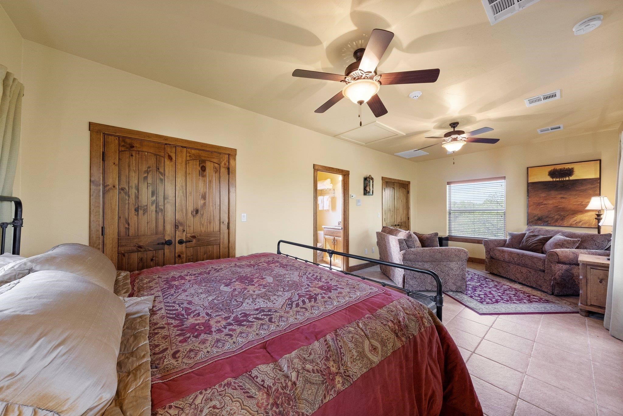 304 Hi Ridge Road Horseshoe Bay, TX 78657 - Photo 29 of 30 a spacious bedroom with a large bed and a chandelier