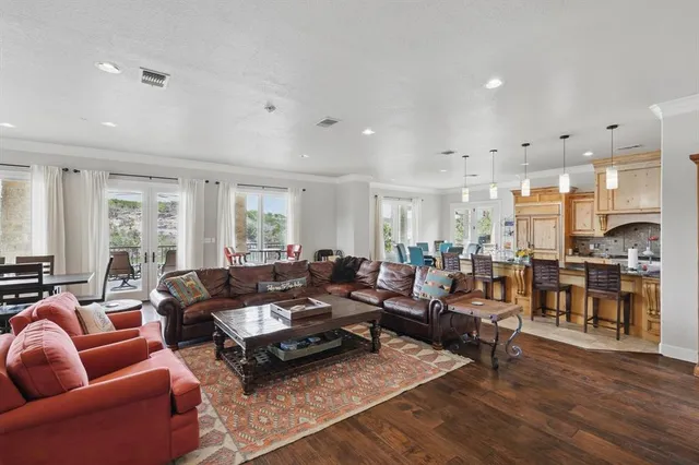 a living room with furniture kitchen view and a large window