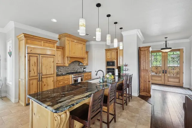 a kitchen with stainless steel appliances granite countertop a sink a stove and a wooden floors