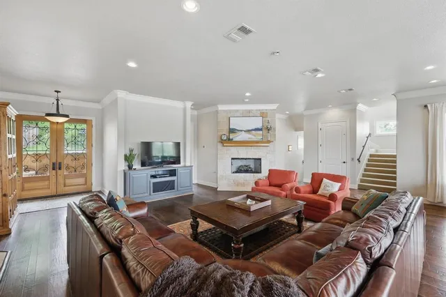 a kitchen with stainless steel appliances granite countertop a stove a refrigerator a sink a dining table and chairs with wooden floor