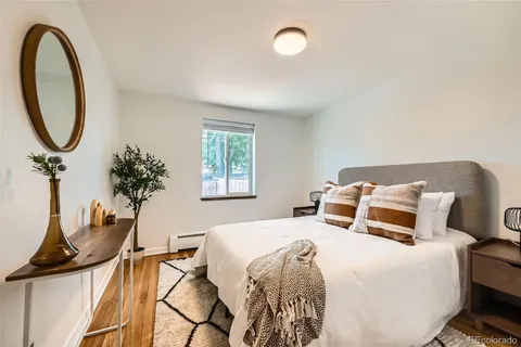 a bedroom with a bed and a potted plant on the dresser