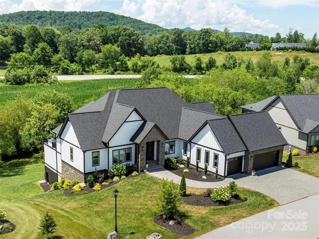 a aerial view of a house next to a yard