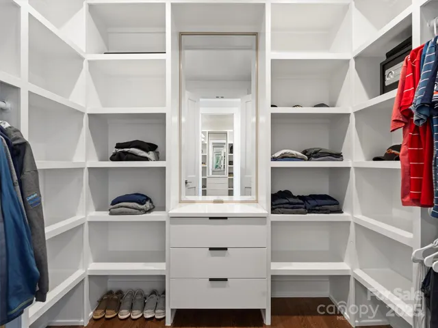 a view of walk in closet with clothes and shoes