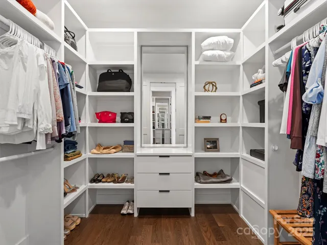 a view of walk in closet with clothes and shoes