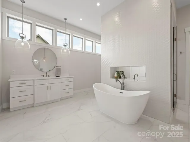 a spacious bathroom with a double vanity sink a mirror and a bathtub