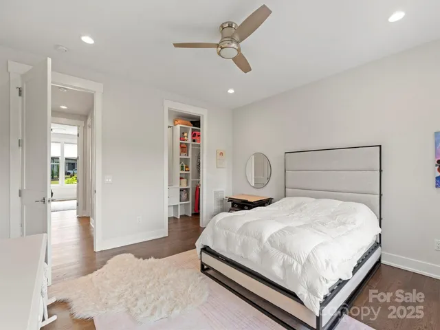 a bedroom with a bed a table and painting on the wall