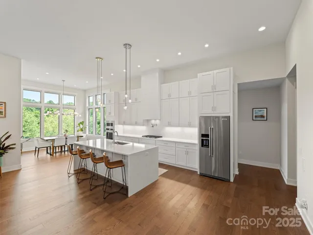 a large white kitchen with lots of counter space and glass door