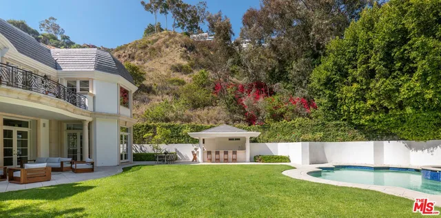 a view of an house with swimming pool and yard