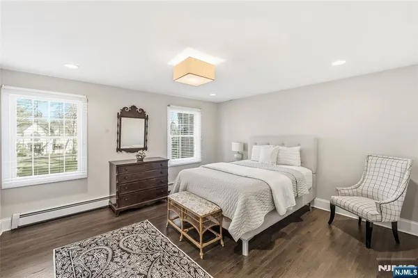 a bed room with a bed couches and a flat tv screen