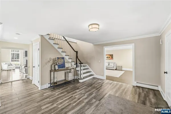 a view of a livingroom with wooden floor and stairs