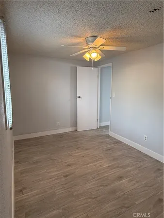 a view of a room with wooden floor and ceiling fan