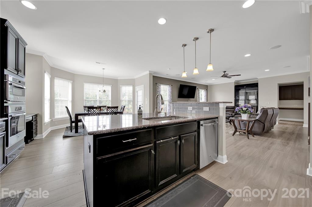 813 Bridge View Court Fort Mill, SC 29708 - Photo 12 of 42 a open kitchen with stainless steel appliances granite countertop a stove top oven a sink dishwasher a dining table and chairs with wooden floor