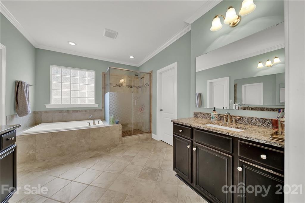 813 Bridge View Court Fort Mill, SC 29708 - Photo 33 of 42 a spacious bathroom with a granite countertop tub sink and mirror