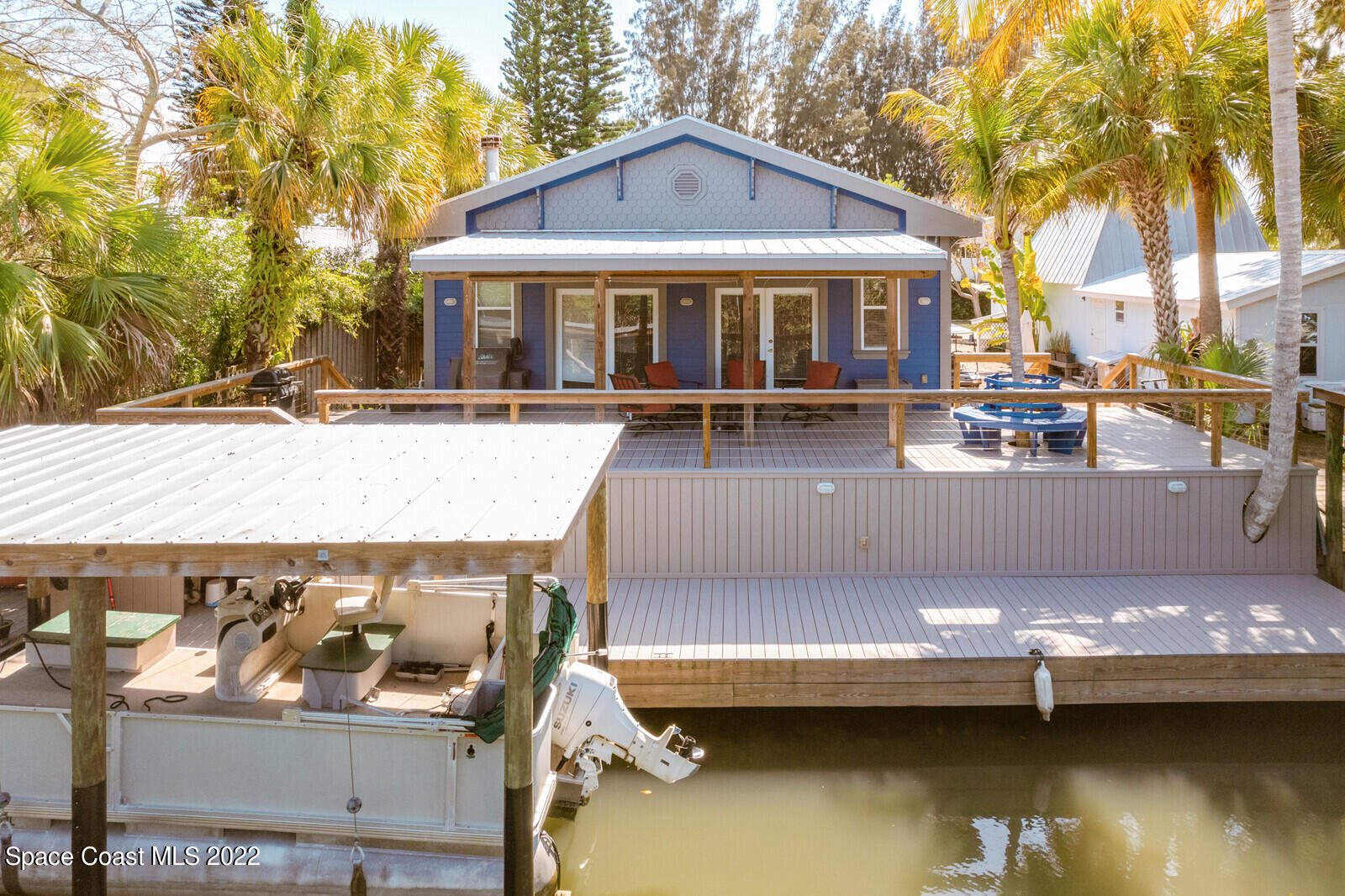 48 Vip Island Grant, FL 32949 - Photo 32 of 38 a view of a house with pool lawn chairs and a barbeque