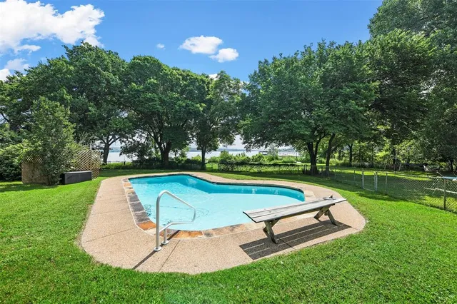 a view of a swimming pool with a garden and trees