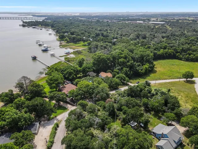 an aerial view of residential houses with outdoor space and trees