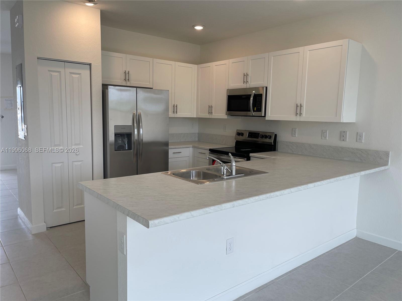 13262 Southwest 287th Terrace Homestead, FL 33033 - Photo 26 of 33 a kitchen with stainless steel appliances a refrigerator sink and microwave
