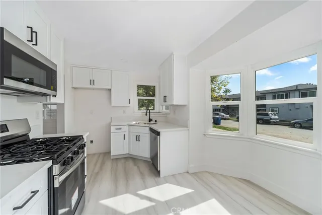 a kitchen with a stove a sink and a microwave