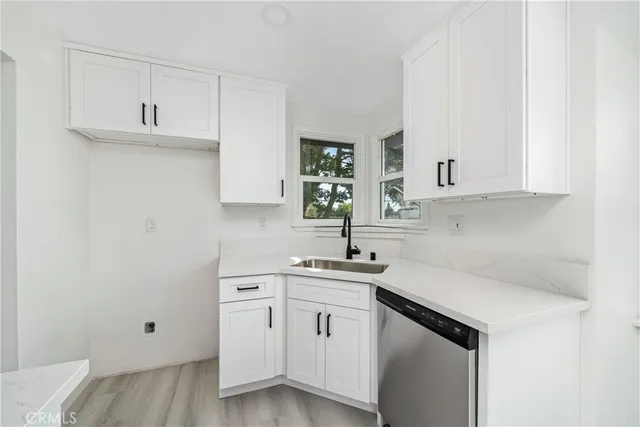 a kitchen with white cabinets and white appliances