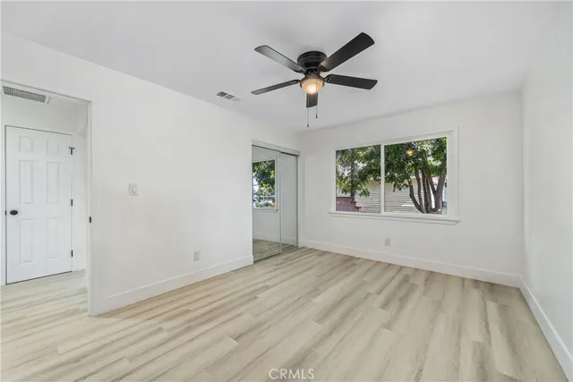 a view of empty room with wooden floor and window