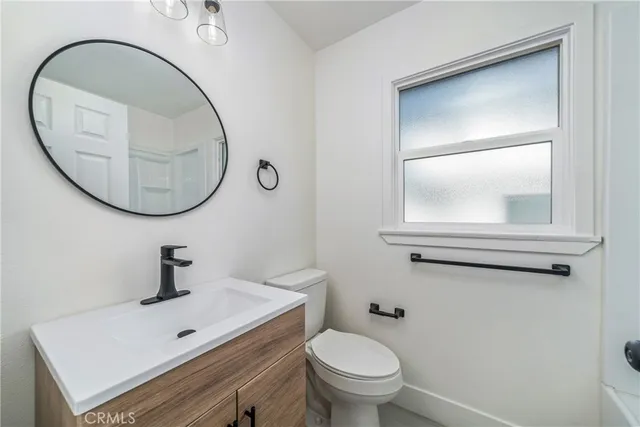 a bathroom with a toilet a sink and mirror