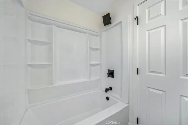 an empty room with a window and a ceiling fan