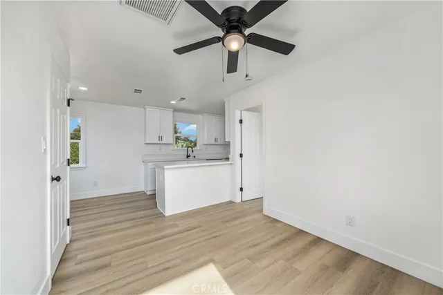 a view of a kitchen with a sink and wooden floor