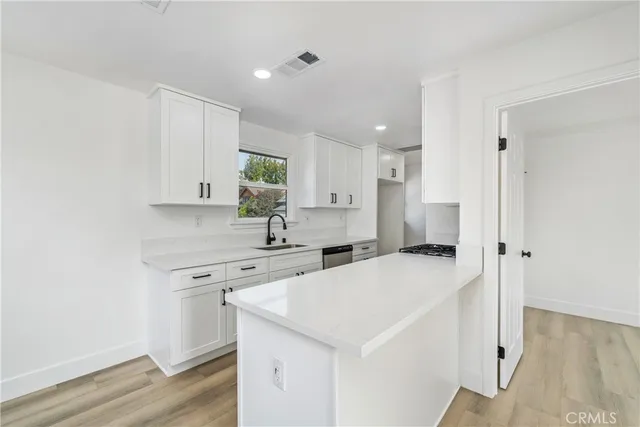 a kitchen with a sink a stove and cabinets