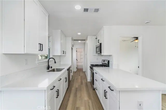 a kitchen with granite countertop a sink stove and refrigerator
