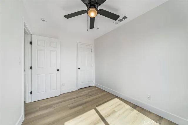 a view of a big room with wooden floor and windows