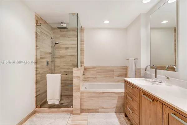 a bathroom with a double vanity sink a mirror and shower